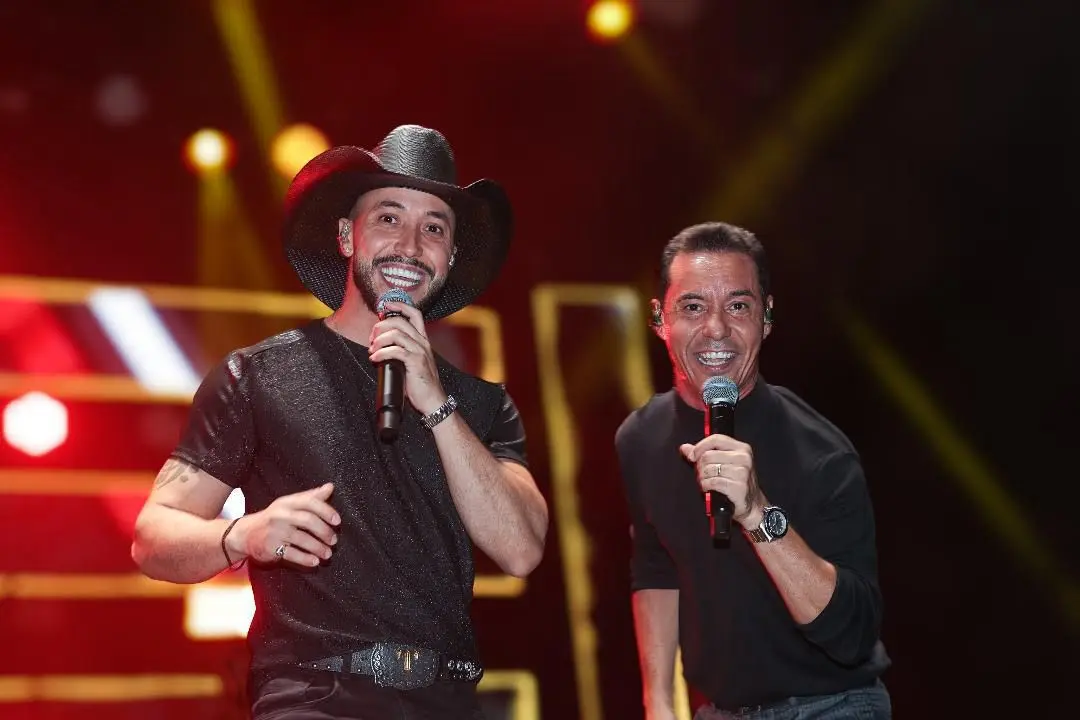 Tato e Júnior sorrindo no palco